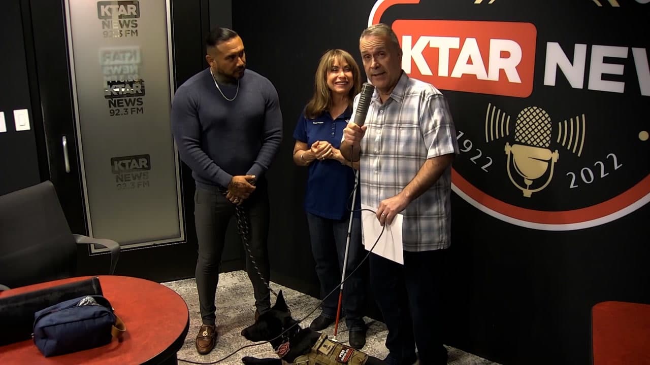 Jaime Martinez in the KTAR News 92.3 FM studio with Paula Pedene, a veteran handler, and a service dog